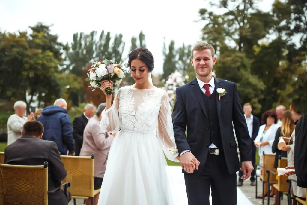 Happy groom and beautiful bride wedding ceremony under the arch decorated with flowers. Wedding day.