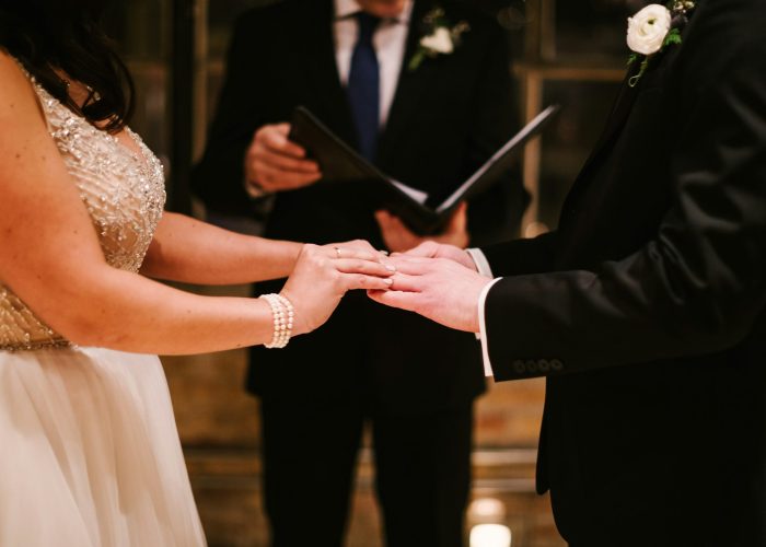 couple at their wedding ceremony, standing at the altar, exchanging rings